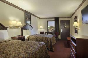 a hotel room with two beds and a television at Days Inn by Wyndham Bainbridge in Bainbridge