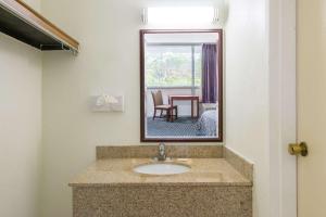 a bathroom with a sink and a mirror at Days Inn by Wyndham Arlington Pentagon in Arlington +15 photos