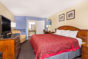 a hotel room with a bed and a television at Days Inn by Wyndham College Park Airport Best Road in Atlanta