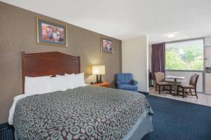 a hotel room with a bed and a table and chairs at Days Inn by Wyndham Arlington Pentagon in Arlington