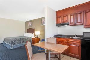 a small hotel room with a bed and a table at Days Inn by Wyndham Arlington Pentagon in Arlington