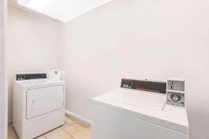 a white laundry room with a washer and dryer at Days Inn by Wyndham Arlington Pentagon in Arlington