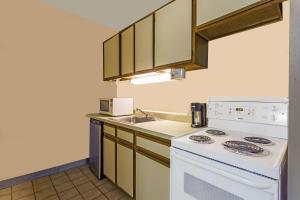a kitchen with a white stove and a sink at Days Inn by Wyndham Virginia Beach At The Beach in Virginia Beach
