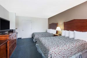a hotel room with two beds and a flat screen tv at Days Inn by Wyndham Arlington Pentagon in Arlington