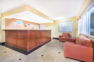 a waiting room with two chairs and a large wooden cabinet at Days Inn by Wyndham Arlington Pentagon in Arlington