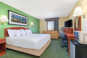 a hotel room with a large bed and a desk at Days Inn by Wyndham Great Bend in Great Bend