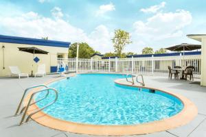 a swimming pool with a patio with a table and chairs at Days Inn by Wyndham Virginia Beach Town Center in Virginia Beach