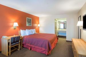 A bed or beds in a room at Days Inn by Wyndham Tucson Airport