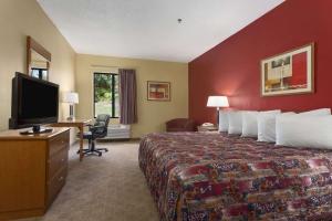 a hotel room with a bed and a flat screen tv at Days Inn by Wyndham Jefferson City in Jefferson City