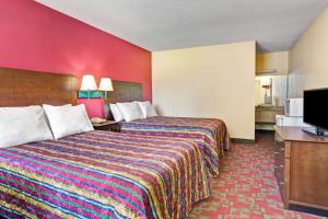 a hotel room with two beds and a flat screen tv at Days Inn by Wyndham Elizabeth City in Elizabeth City