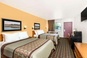 um quarto de hotel com duas camas e uma televisão em Days Inn by Wyndham Little River em Little River