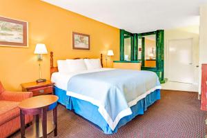a hotel room with a large bed and a couch at Days Inn by Wyndham Covington in Covington