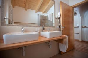 łazienka z 2 umywalkami i lustrem w obiekcie Apartaments Galina w mieście Selva di Val Gardena