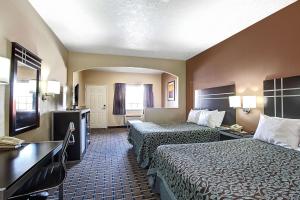 Habitación de hotel con 2 camas y escritorio en Days Inn & Suites by Wyndham Houston North - Spring en Westfield