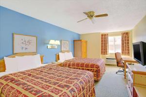 A bed or beds in a room at Days Inn by Wyndham Lehi