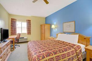 a hotel room with a bed and a flat screen tv at Days Inn by Wyndham Lehi in Lehi