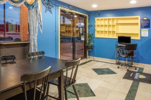 een tafel en stoelen in een kamer met een blauwe muur bij Days Inn by Wyndham Bastrop in Bastrop