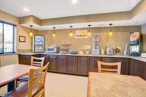 a restaurant with a table and chairs and a counter at Days Inn by Wyndham Woodland in Woodland