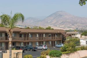 een hotel met auto's geparkeerd op een parkeerplaats bij Days Inn by Wyndham in San Bernardino in San Bernardino