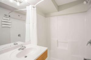 a white bathroom with a sink and a shower at Days Inn by Wyndham Custer in Custer +15 photos
