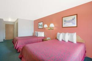 2 camas en una habitación de hotel con paredes rojas en Days Inn by Wyndham Custer, en Custer