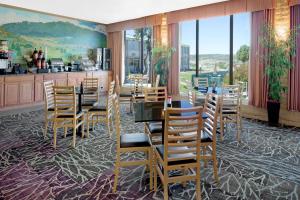 une salle à manger avec une table, des chaises et des fenêtres dans l'établissement Days Inn by Wyndham Colorado City, à Colorado City