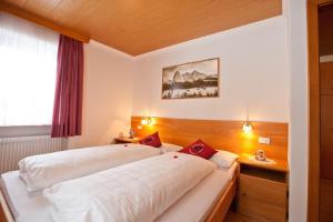 a hotel room with two beds and a window at Apartaments Galina in Selva di Val Gardena