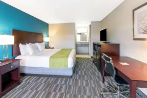 a hotel room with a bed and a desk at Days Inn by Wyndham Snyder in Snyder