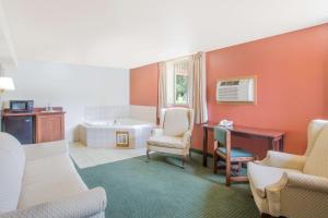 a bathroom with a tub and a desk and chairs at Days Inn by Wyndham Custer in Custer