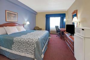 a hotel room with a bed and a flat screen tv at Days Inn by Wyndham Laramie in Laramie