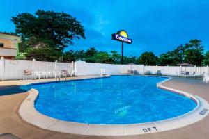 een zwembad in een resort met stoelen en een bord bij Days Inn by Wyndham Tannersville in Tannersville
