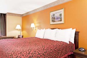 Habitación de hotel con cama con colcha roja en Sunset Inn Daytona Beach en Daytona Beach