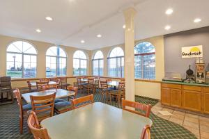 a restaurant with tables and chairs and windows at Days Inn by Wyndham Laramie in Laramie
