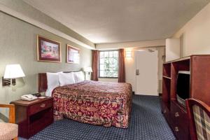 a hotel room with a bed and a television at Days Inn by Wyndham Dumfries Quantico in Dumfries