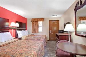 a hotel room with two beds and a table at Days Inn by Wyndham Ridgefield NJ in Ridgefield