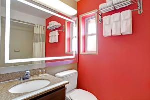 a red bathroom with a toilet and a sink at Days Inn by Wyndham Ridgefield NJ in Ridgefield