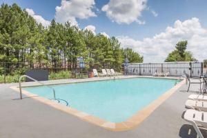 a large swimming pool with chairs and a fence at Days Inn & Suites by Wyndham Marshall in Marshall