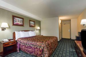 a hotel room with a bed and a television at Days Inn by Wyndham Dumfries Quantico in Dumfries