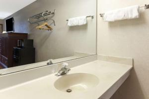a bathroom with a sink and a mirror at Days Inn by Wyndham Maumee/Toledo in Maumee +16 photos