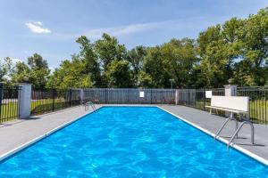 a swimming pool with a fence and blue water at Days Inn by Wyndham Martin in Martin