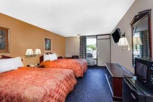 a hotel room with two beds and a flat screen tv at Days Inn by Wyndham Martin in Martin