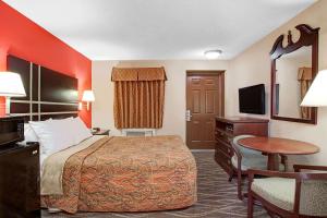 a hotel room with a bed and a table at Days Inn by Wyndham Ridgefield NJ in Ridgefield