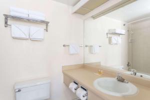 a bathroom with a sink and a toilet and a mirror at Days Inn by Wyndham Evanston WY in Evanston