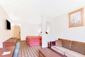 a hotel room with a couch and a bed at Days Inn & Suites by Wyndham Laredo in Laredo