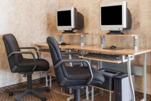 una oficina con tres escritorios con ordenadores. en Days Inn by Wyndham Hillsboro TX, en Hillsboro