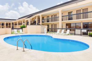 a large swimming pool in front of a building at Days Inn by Wyndham Greenville MS in Greenville