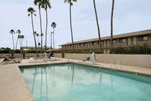 a swimming pool in front of a building with palm trees at Americas Best Value Inn Blythe CA in Blythe