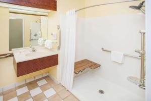 a bathroom with a sink and a shower at Days Inn & Suites by Wyndham Harvey / Chicago Southland in Harvey