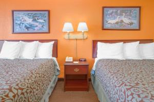 a hotel room with two beds and a table with two lamps at Days Inn by Wyndham Okemah in Okemah
