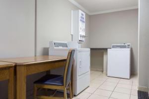 a kitchen with a table and a refrigerator at Days Inn by Wyndham Florence Cincinnati Area in Florence